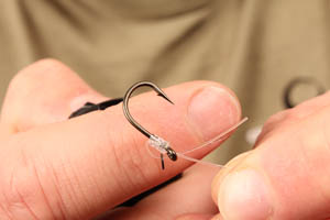 5. thread on a small Covert rig ring and pass the tag end back through the eye of the hook.