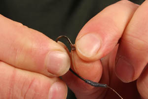 Step 4. Thread the first Covert Hook Stop onto the hook, so that the widest end is facing up the shank.