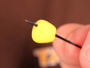 Step 2. Pierce a piece of bouyant Enterprise Tackle imitation corn through the narrow end first with a baiting needle as shown.