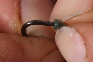Step 4. Next thread on a Covert Hook Stop carefully teasing it over the barb to maintain its grip.