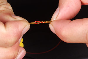 Step 7. Gently pull the knot down, teasing the knot with your fingers so that the coils group up neatly and lock.
