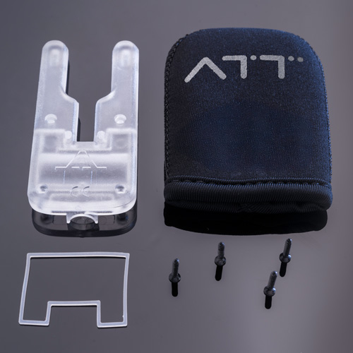 The ATTci Replacement Back Plate includes a clear plastic tool, a black fabric pouch with white symbols, a small clear rectangular piece, and four black screws, all neatly arranged on a dark reflective surface.