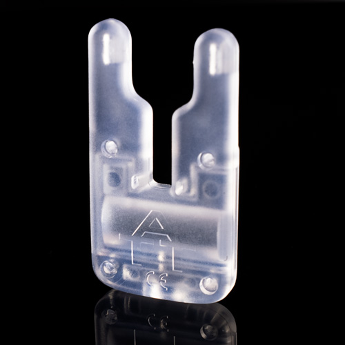 The ATTci Replacement Back Plate is a translucent, U-shaped plastic clip with two prongs and a small engraved symbol on the front, shown standing upright on a reflective black surface.