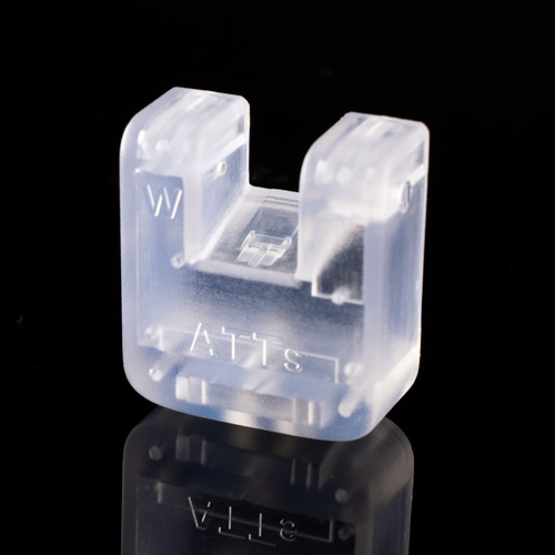 The ATTci Replacement Back Plate, a translucent plastic part with W and ATT markings, stands upright on a reflective black surface.